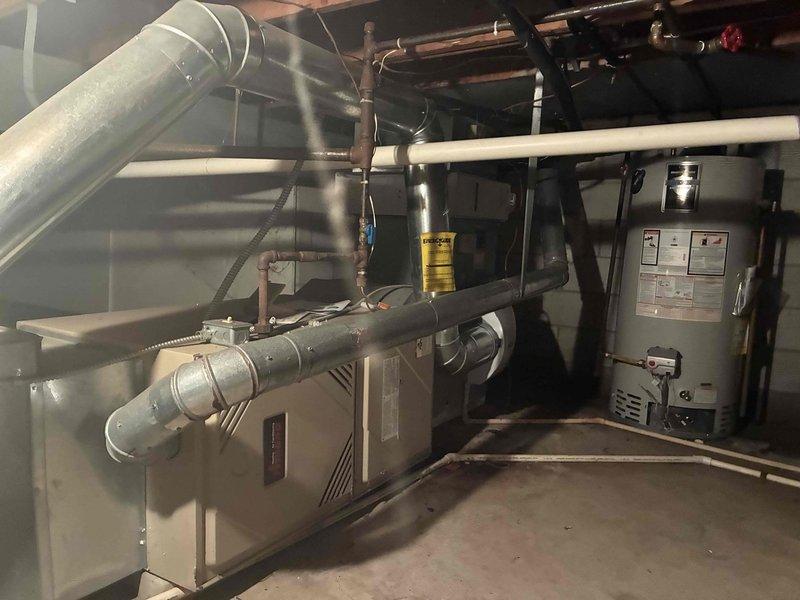 Conducted estimate for residential HVAC system experiencing refrigerant loss and freeze-up conditions. System operating on R22 refrigerant was determined to be beyond economical repair due to age and extent of required work. Documented existing basement installation including furnace, ductwork configuration, and connected water heater for replacement specifications. Provided comprehensive assessment and recommended full system replacement as most cost-effective solution.