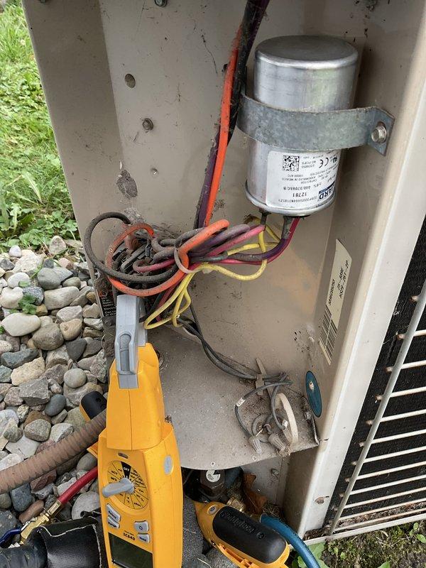 # HVAC Service Report

## Summary
Responded to no-cooling call on 10+ year old outdoor AC unit with non-operational condenser fan. Diagnosed and replaced failed dual run capacitor, restoring proper fan operation and cooling function to the system.

## Work Performed

Upon arrival, confirmed condenser fan motor was not running while compressor attempted to operate. Performed visual inspection of outdoor unit, noting significant age-related wear and weathering on cabinet and components. 

Opened service panel and accessed electrical components. Used multimeter to test dual run capacitor, which showed complete failure with no capacitance reading on fan circuit. Capacitor exhibited visible signs of deterioration consistent with age and outdoor exposure.

Verified electrical supply at disconnect box mounted on exterior wall. Inspected disconnect switch and wiring connections, noting corrosion on conduit penetrations but functional disconnect operation. Confirmed proper voltage supply to uni
