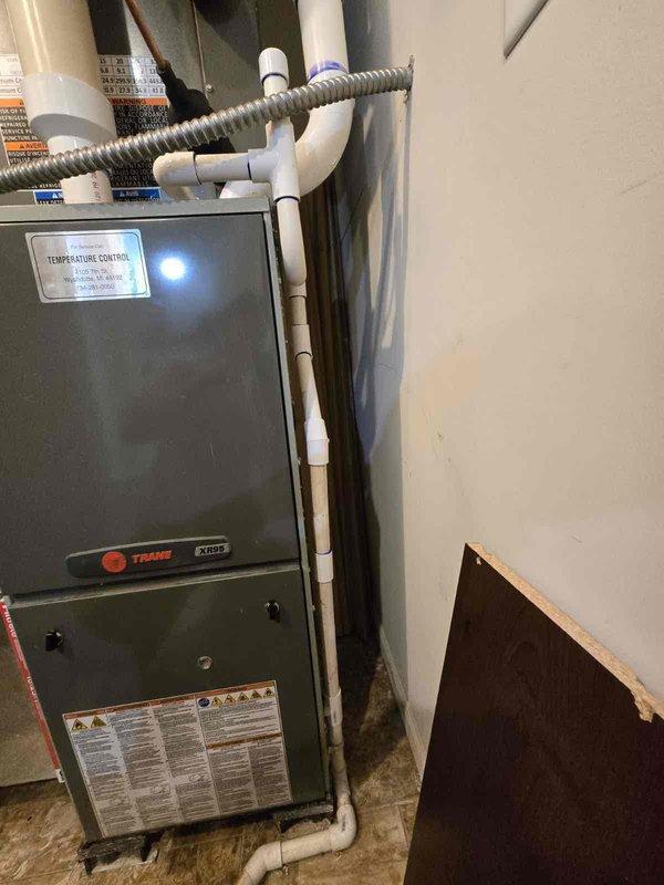 Completed mechanical installation of 3-ton air conditioning system at rear of residence. Installed outdoor condensing unit on concrete pad with proper clearances from structure, connected refrigerant lines, and established condensate drainage via PVC piping routed vertically along exterior siding. Reconnected system to existing Trane XR80 furnace with appropriate electrical connections and verified proper integration between indoor and outdoor components. All refrigerant lines, electrical connections, and condensate drainage systems installed per manufacturer specifications and code requirements.