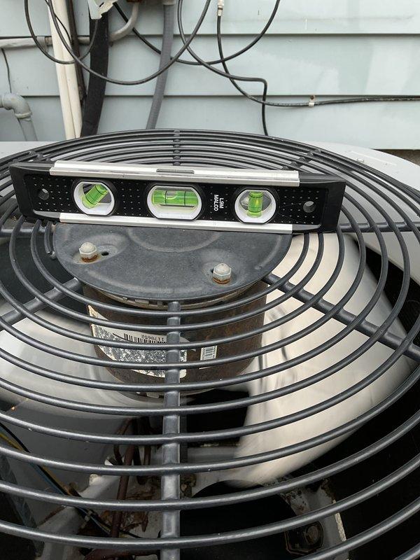 Responded to no cooling complaint on aging air conditioning system. Upon arrival, found unit operating continuously per customer request despite warm air discharge. Performed system inspection including electrical disconnect examination and condenser unit assessment. Verified unit levelness and documented electrical connections at service disconnect showing multiple wire terminations and proper grounding configuration. Inspected outdoor condenser unit with fan assembly operational, though system failing to provide adequate cooling. Customer declined to power down system during diagnostic evaluation, limiting troubleshooting capabilities for refrigerant charge verification and compressor amperage testing under proper conditions.