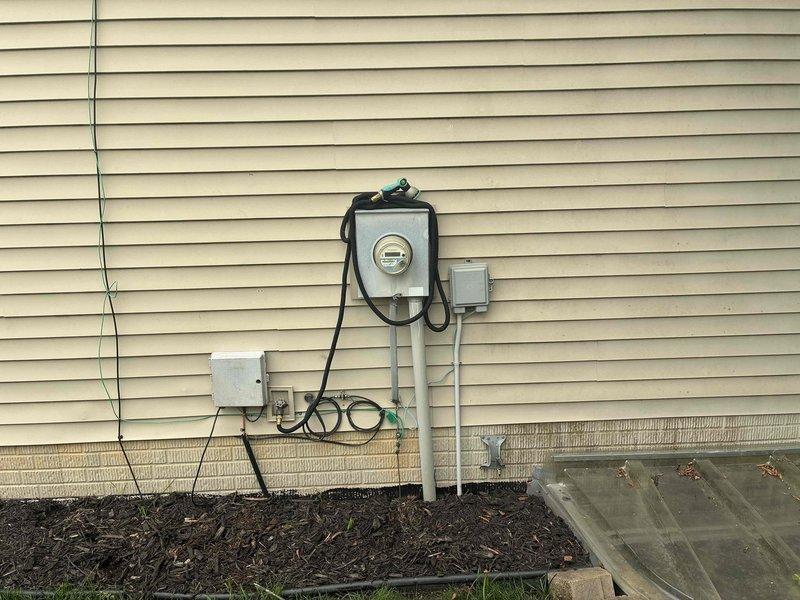 Conducted comprehensive site assessment for whole home generator installation. Evaluated existing electrical service infrastructure including main meter enclosure, junction boxes, and conduit routing on exterior wall. Documented current electrical panel location and available connection points for generator transfer switch integration. Assessed natural gas utility meter and supply line configuration to determine fuel source viability and connection requirements for proposed generator system. Identified optimal generator placement location considering clearance requirements from structure, utility meters, and landscaping features. Verified adequate foundation support area and documented accessibility for installation and future maintenance access.