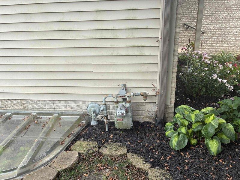 Conducted comprehensive site assessment for whole home generator installation. Evaluated existing electrical service infrastructure including main meter enclosure, junction boxes, and conduit routing on exterior wall. Documented current electrical panel location and available connection points for generator transfer switch integration. Assessed natural gas utility meter and supply line configuration to determine fuel source viability and connection requirements for proposed generator system. Identified optimal generator placement location considering clearance requirements from structure, utility meters, and landscaping features. Verified adequate foundation support area and documented accessibility for installation and future maintenance access.