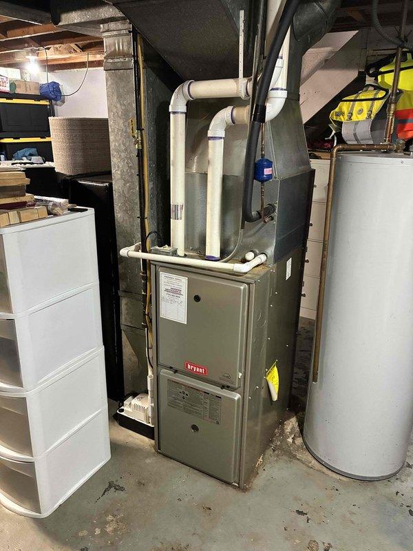 Completed comprehensive assessment of 15-year-old residential air conditioning system experiencing multiple component failures. Diagnosed failed contactor and capacitor, along with severe refrigerant undercharge condition. Documented existing Bryant HVAC system installation in basement utility area, including furnace unit and associated ductwork configuration. Provided detailed replacement estimate for aging AC system given the extent of repairs needed and age of equipment.