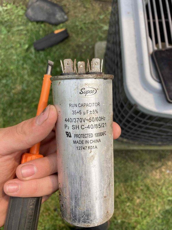 # HVAC Service Completion

Responded to no cooling call on residential air conditioning system over 10 years old. Upon arrival, performed diagnostic evaluation of outdoor condensing unit. Testing revealed failed dual run capacitor (35+5 μF, 440V) preventing compressor and condenser fan motor operation. Removed defective capacitor and installed new Supco replacement capacitor with matching specifications. 

Inspection of condenser coil revealed heavy accumulation of dirt, dust, and debris restricting airflow through fins. Coil contamination significantly reduced heat transfer efficiency and system performance. Noted dense fibrous material buildup along top edge of coil assembly. Cleaned condenser coil to restore proper airflow and heat rejection capacity.

Verified system operation after repairs. Compressor and condenser fan motor running properly. Unit cycling normally with adequate cooling performance restored. Recommended regular maintenance schedule to prevent future coil contaminat