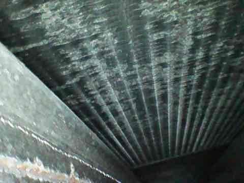 Completed routine AC Club preventive maintenance inspection on air conditioning system. Upon inspection, discovered significant frost and ice buildup on evaporator coil fins and internal components, indicating potential airflow restriction, refrigerant issues, or system operational problems. Documented system condition with photographs showing heavy crystalline deposits across heat exchanger surfaces and interior ductwork. Inspected corrugated duct interior and confirmed structural integrity of ventilation components.