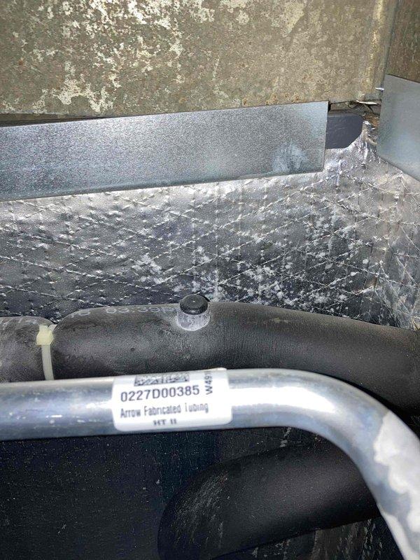 Completed preventive maintenance agreement visit on club AC8-12 system. Performed comprehensive inspection of indoor unit components including refrigerant line set, condensate drain pan, and cabinet assembly. Refrigerant lines with black foam insulation were inspected and found in serviceable condition with manufacturer identification visible. Condensate pan showed evidence of normal operational water accumulation with mineral deposits present, indicating proper drainage function. All accessible components were visually inspected and system found to be operating within normal parameters for continued service under maintenance agreement.