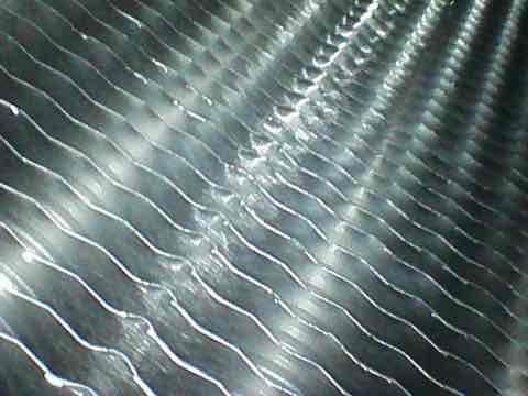 Responded to customer concern regarding inadequate cooling performance. Performed comprehensive system tune-up and inspection of HVAC unit. Examined condenser coil fins, which appeared clean and in good condition with proper spacing and no visible damage. Accessed equipment located in basement stairwell area. Completed full diagnostic evaluation to identify cause of reduced cooling capacity and verified system operation parameters.