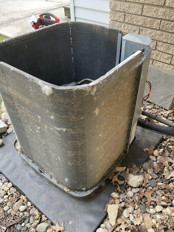 Responded to emergency no-heat call for a 5-year-old Goodman GSX130361EH system that was circulating air but not providing heat. Upon arrival, inspected outdoor condenser unit which showed significant dirt and debris accumulation on exterior surfaces and top grille, indicating lack of routine maintenance. Verified unit model and specifications from manufacturer nameplate, confirmed 208/230V power supply at disconnect box, and documented equipment condition. System blower operation confirmed but heating function not operational, requiring further diagnostic evaluation of heat source components.