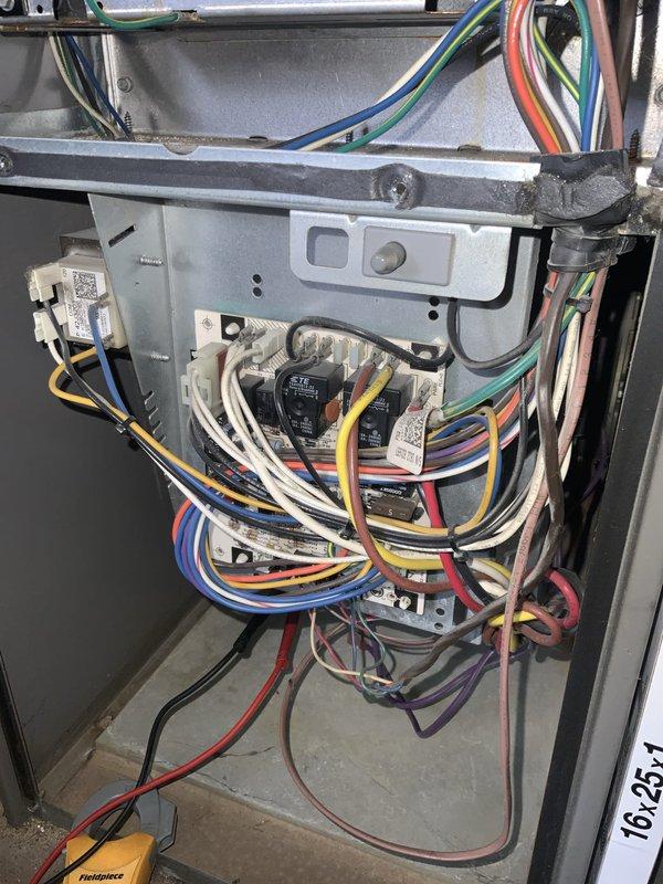 Responded to no cooling call on 15-year-old residential AC system. Upon arrival, performed diagnostic evaluation of unit including electrical system inspection and component testing. Accessed interior panels to examine wiring connections, control boards, and relay components. Utilized multimeter and diagnostic tools to test electrical continuity and identify failure points. Documented system condition with photos showing internal wiring configuration and overall equipment status. Completed thorough assessment of aging HVAC equipment to determine cause of complete system failure and provided findings to customer for repair recommendations.