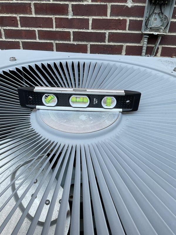 # HVAC Service Report

Responded to no cooling complaint with unit intermittently tripping and shutting down. Upon arrival, found outdoor condenser unit significantly unlevel, which can cause compressor oil migration issues and premature component failure. Used precision level to verify unit was out of specification on mounting pad. Checked unit levelness in multiple directions to assess severity of installation issue. Unit's unlevel condition likely contributing to electrical safety trips and operational shutdowns. Documented current positioning for correction requirements. Recommended immediate releveling of condenser unit on pad to prevent compressor damage and restore proper system operation.