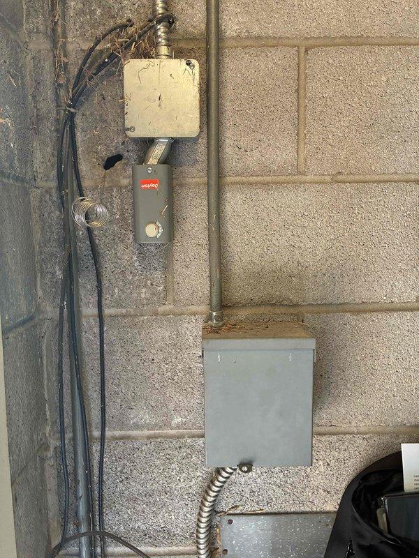 Conducted on-site assessment for air conditioning system replacement. Evaluated existing White-Rodgers thermostat and outdoor electrical components including junction box, control switch, and electrical panel mounted on exterior wall. Documented current equipment condition and provided comprehensive replacement quote for new AC system.