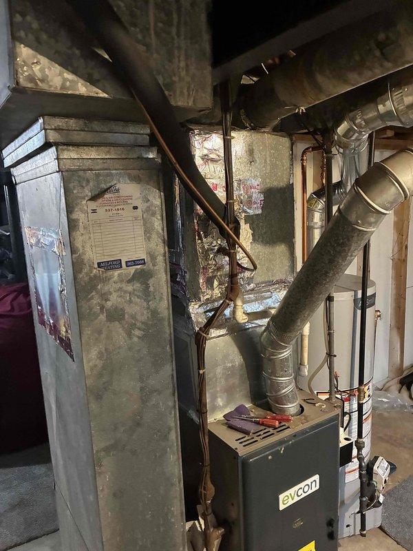 Conducted estimate for complete HVAC system replacement after assessing existing basement furnace and outdoor condensing unit. System sustained damage from recent power outage, requiring control board and low pressure cutoff switch at minimum, with potential for additional failed components making repairs economically unfeasible. Documented condition of aged Evcon furnace, air handler, ductwork, and outdoor AC unit through photographic inspection. Recommended full system replacement of both heating and cooling equipment due to extent of electrical damage and overall age of installation.