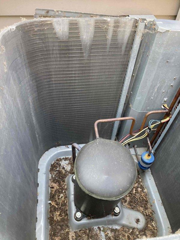 Completed scheduled Club AC10-2 preventive maintenance agreement visit on air conditioning system. Upon arrival, performed comprehensive system inspection and operational assessment. Measured electrical current draw at 46.2 amperes using calibrated clamp meter to verify compressor performance within manufacturer specifications. 

Inspected condenser unit interior, noting moderate dust and debris accumulation on evaporator coil fins and significant organic debris collection around compressor base. Observed copper refrigerant lines and electrical connections in serviceable condition with minor surface oxidation consistent with unit age. Verified capacitor mounting and connections secure. System operational at time of inspection with all components functioning as designed. Documented equipment condition with photographic evidence for maintenance records.