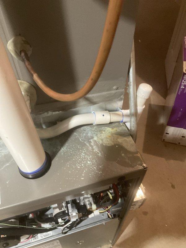 # HVAC Maintenance Visit - System Tune-Up with Critical Cooling Issue

Performed comprehensive maintenance tune-up on residential HVAC system as part of recurring service agreement. Upon arrival, discovered severe ice and frost accumulation on the air handler unit's exterior casing and top surfaces, indicating a significant cooling system malfunction. The extensive frost buildup suggested potential issues with airflow restriction, refrigerant charge imbalance, or drainage problems requiring immediate attention.

Removed lower access panel to inspect internal components, including electrical wiring, circuit boards, and mechanical assemblies. Evaluated condensate drainage system and refrigerant line connections, including white PVC piping and flexible discharge lines. Assessed the unit's control systems and electrical connections to identify root cause of icing condition. Documented the frost accumulation and system configuration through photographic evidence for service records.

The ic