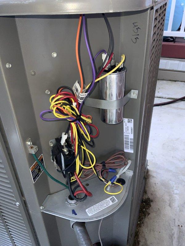 Responded to no cooling call on residential air conditioning system installed two years prior by another contractor. Upon arrival, accessed outdoor condensing unit and performed diagnostic evaluation of electrical components, controls, and capacitor. Inspected internal wiring connections, contactor operation, and capacitor condition to identify cause of complete cooling failure. Documented system condition with photos showing electrical compartment layout and component configuration for service records.