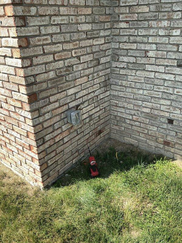 Installed GFCI outlet in exterior weatherproof box mounted on brick wall foundation. Tested installed receptacle using Klein Tools electrical tester, which confirmed proper voltage reading of 122V and verified correct GFCI functionality and ground protection.