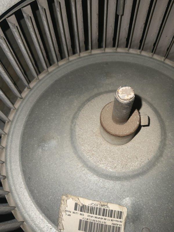Responded to no cooling call on 20-year-old central air conditioning system. Customer reported air handler blowing room temperature air with outdoor condenser fan running but no cooling output. Upon arrival, performed system diagnostics and found blower motor operational and air filter moderately loaded with dust and debris. Inspected indoor air handler components including blower assembly and motor shaft, which showed normal wear consistent with age. Outdoor unit condenser fan confirmed running, indicating potential refrigerant system issue or compressor failure. Given the advanced age of the system at 20 years—well beyond typical 10-15 year equipment lifespan—recommended full system evaluation including refrigerant pressure testing, compressor amperage draw analysis, and capacitor testing to determine root cause of cooling failure. Documented equipment condition through photographic evidence of blower assembly and air filtration system for customer records.