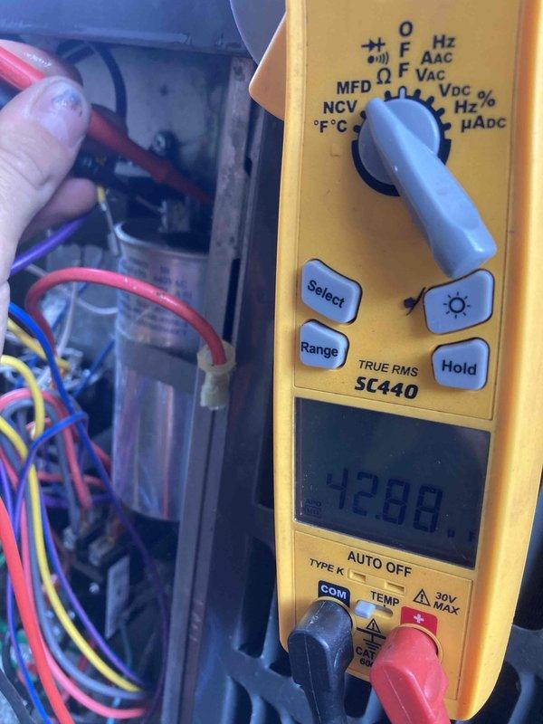 Completed prepaid air conditioner maintenance tune-up on residential AC system with no reported symptoms or issues. Performed comprehensive electrical diagnostics using digital multimeter, measuring voltage readings at control panel which displayed 4288 on initial reading and subsequent measurements of 40.3. Inspected control panel wiring connections including red, blue, yellow, white, and purple conductors to verify proper terminations and system integrity. All electrical components tested within normal operating parameters and system found to be functioning properly upon completion of preventive maintenance service.