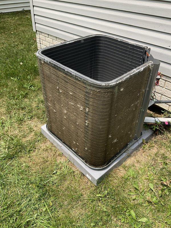 Completed scheduled preventative maintenance on residential air conditioning system. Performed comprehensive tune-up including inspection of condensing unit, refrigerant lines, and electrical connections. Unit exterior showed significant weathering, dirt accumulation, and biological growth requiring attention during service. Cleaned condenser coils, verified proper airflow through louvers and fins, and inspected internal components with top panel removed. Checked refrigerant line connections and electrical conduit for proper installation and secure mounting. System operational with no mechanical issues identified during inspection.