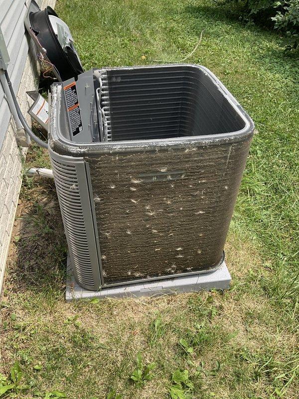Completed scheduled preventative maintenance on residential air conditioning system. Performed comprehensive tune-up including inspection of condensing unit, refrigerant lines, and electrical connections. Unit exterior showed significant weathering, dirt accumulation, and biological growth requiring attention during service. Cleaned condenser coils, verified proper airflow through louvers and fins, and inspected internal components with top panel removed. Checked refrigerant line connections and electrical conduit for proper installation and secure mounting. System operational with no mechanical issues identified during inspection.