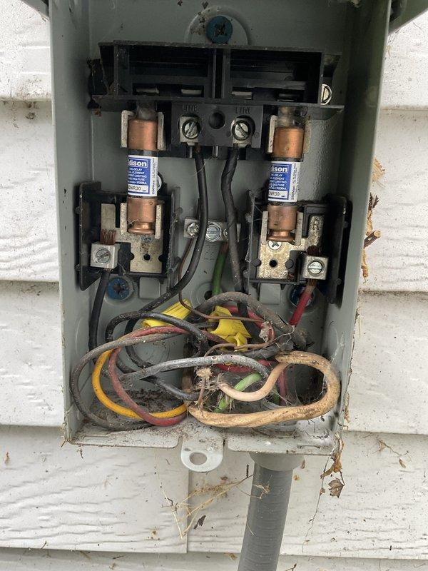 # HVAC Service - No Cool 10+ Years Old

Responded to no cooling complaint on aging residential air conditioning system. Upon arrival, confirmed unit was running but delivering warm air to conditioned space. Performed visual inspection of outdoor disconnect box and found significant deterioration of electrical components including corroded fuse holders, oxidized wire connections, and aged wiring with compromised insulation. Noted extensive rust formation on metal enclosure components and terminal connections indicating prolonged exposure to weather and moisture.

Inspected evaporator coil assembly and observed accumulated debris between fins restricting airflow. Coil showed signs of reduced efficiency due to age-related deterioration and inadequate maintenance history. System exhibited multiple failure points consistent with equipment exceeding recommended service life.

Documented current conditions through photographic evidence showing electrical safety concerns and compromised system