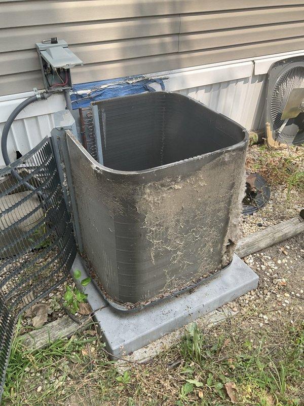 Responded to no cooling complaint on outdoor condensing unit. Upon arrival, found system inoperative with heavily weathered exterior showing significant corrosion and rust staining. Performed diagnostic evaluation of unit, inspected electrical connections at disconnect box, and assessed internal components including condenser coils. Unit exhibited extensive age-related deterioration despite being under 10 years old, with visible environmental damage to exterior panels and evidence of poor drainage around concrete pad contributing to accelerated corrosion. Completed system assessment and provided findings to customer regarding equipment condition and cooling failure.