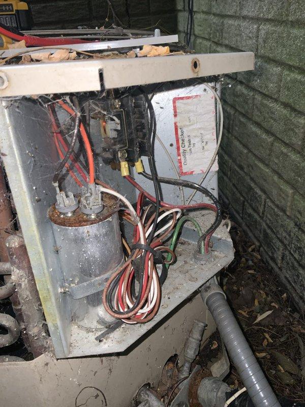 # HVAC Service Report

## Summary
Responded to no cooling complaint on 35-year-old central air conditioning system. Upon inspection, found severely deteriorated outdoor condensing unit with corroded capacitor, loose electrical connections, and compromised wiring throughout electrical compartment, indicating system had reached end of serviceable life and required full replacement.

## Work Performed

Arrived on site to diagnose non-operational central air conditioning system reported as producing no cold air. Conducted visual inspection of outdoor condensing unit and found equipment to be approximately 35 years old, well beyond typical 15-20 year service life expectancy.

Removed access panel from condensing unit to inspect electrical components and internal systems. Discovered extensive deterioration throughout electrical compartment. Run capacitor exhibited severe corrosion and rust staining, indicating prolonged exposure to moisture and environmental elements. Multiple electrical con