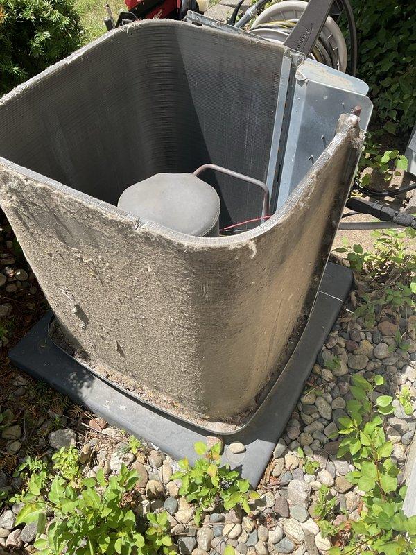 # HVAC Maintenance - Agreement Visit Summary

Completed prepaid seasonal air conditioning tune-up maintenance on outdoor condensing unit with no reported operational issues or customer concerns.

# Work Performed

Performed comprehensive preventive maintenance inspection on residential outdoor AC condensing unit housed within concrete enclosure. Conducted visual assessment of system components including condenser coil, compressor housing, and refrigerant lines. Inspected aluminum fin condition on heat exchanger, which showed acceptable cleanliness levels with metallic surfaces intact. 

Examined concrete protective housing surrounding unit, noting significant weathering, surface erosion, and visible cracking consistent with extended environmental exposure. Documented aged appearance of exterior enclosure while confirming structural integrity remains adequate for continued equipment protection.

Verified proper positioning of condensate drainage components and plastic drain pan beneath 
