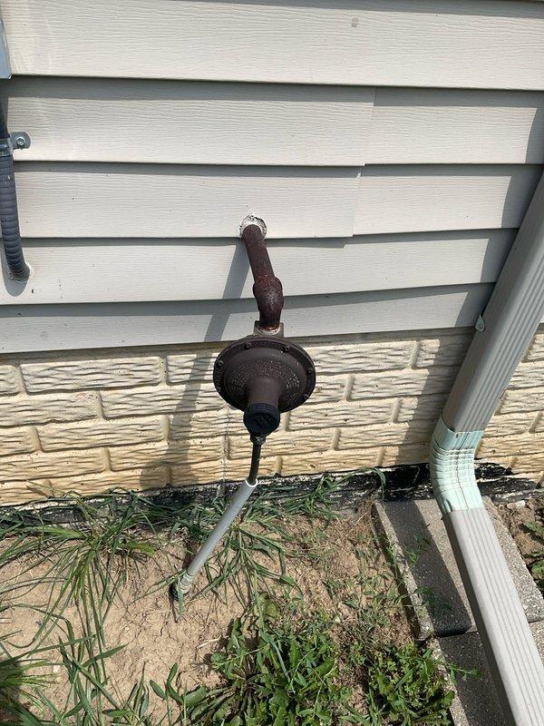 Conducted on-site evaluation for new whole home generator installation at manufactured home. Assessed existing gas service infrastructure, including red gas regulator valve and gas line routing along exterior wall. Documented current utility connections and identified optimal placement for generator unit, considering gas line accessibility and electrical service panel proximity. Noted existing infrastructure conditions including weathered exterior surfaces and aged gas piping with visible corrosion requiring consideration for safe generator integration.