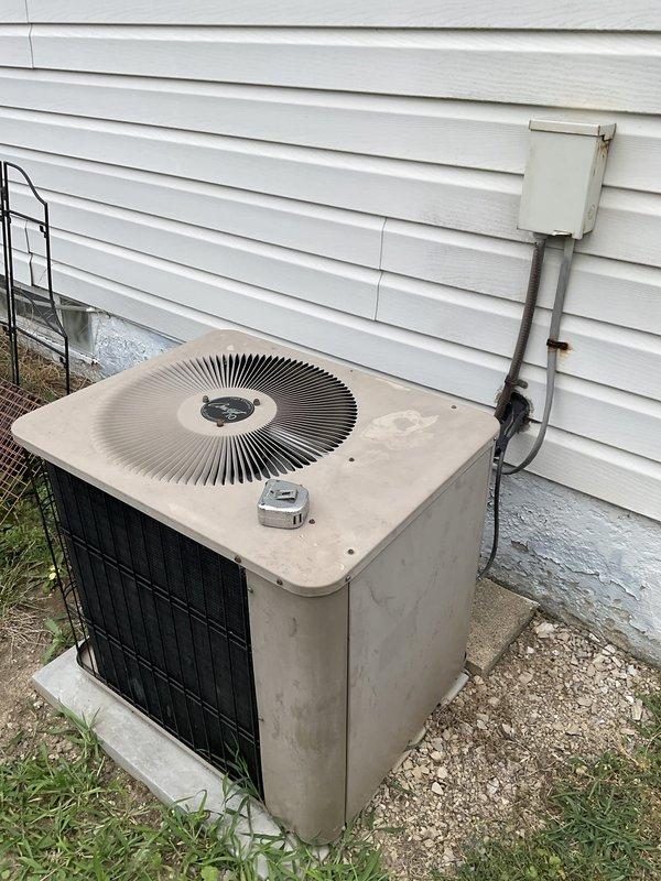 Completed HVAC system estimate for replacement of 30-year-old residential air conditioning and heating system. Current furnace operational but air conditioning unit non-functional. Assessed outdoor condenser unit on concrete pad showing significant weathering and age-related deterioration, along with basement furnace and ductwork system utilizing natural gas fuel source.
