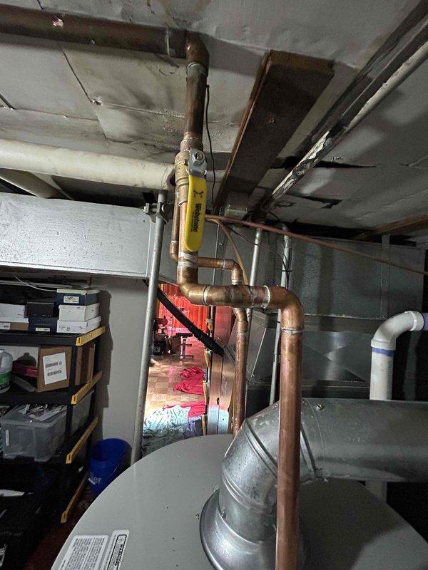 Completed mechanical-only installation of tanked water heater in basement utility area with reconnection of existing copper supply and distribution piping. Unit was positioned in mechanical room, all plumbing connections were made to the top-mounted inlet and outlet ports, and system was tested for proper operation. Installation was performed as a payment-upon-completion service with mechanical work only per customer request.