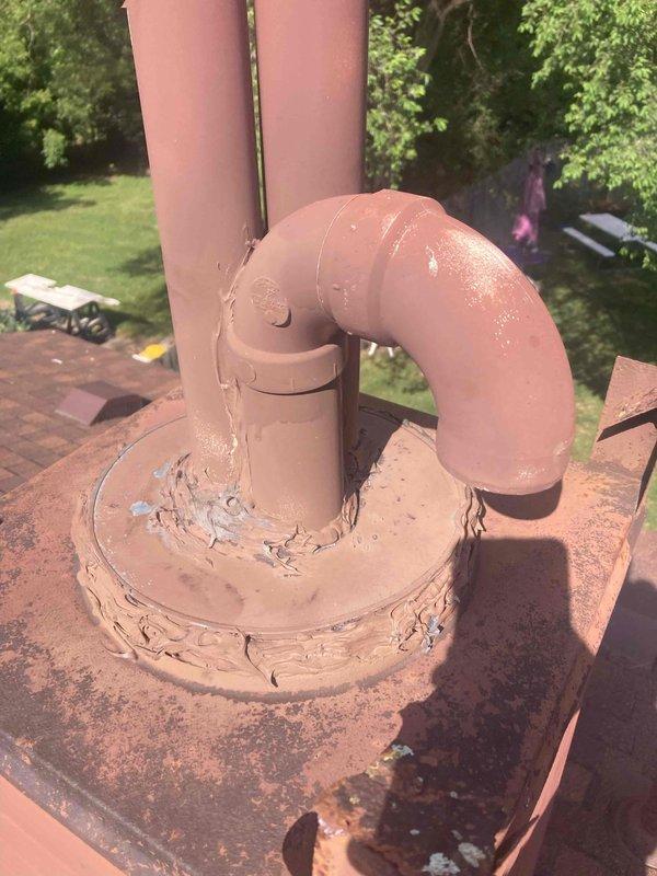 Responded to callback for water heater venting leak. Upon inspection, identified compromised weatherproofing at vent pipe penetration on metal roof panel, with significant rust and corrosion present on flashing. Documented deteriorated sealant and flashing conditions at both the metal roof penetration point and secondary vent stack location on shingled roof section, where aged roofing tar and rusted flashing were contributing to water infiltration at venting assembly.
