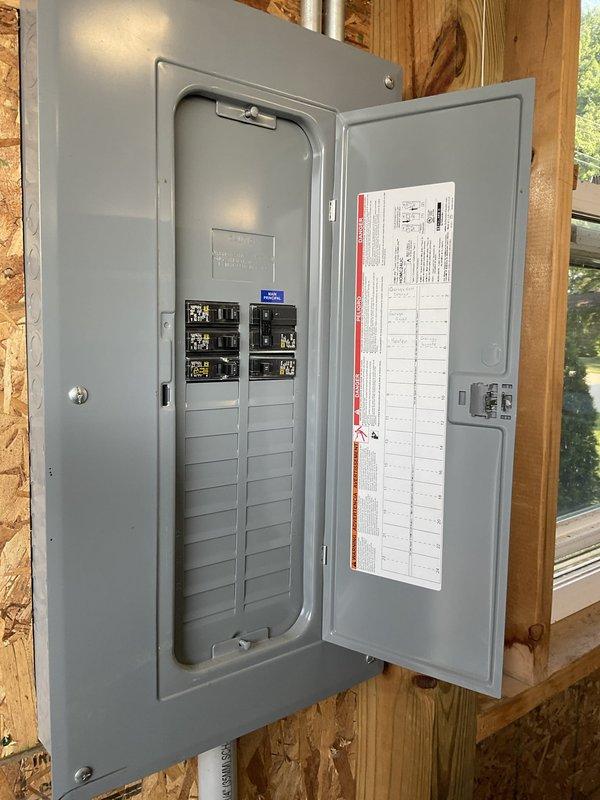 Conducted on-site assessment for mini split installation in garage workshop space with OSB wall construction and exposed wooden framing. Evaluated electrical infrastructure including existing breaker panel with available circuit capacity and determined optimal equipment placement considering workspace layout and existing mechanical systems. Documented installation location requirements and electrical service compatibility for proposed mini split system.