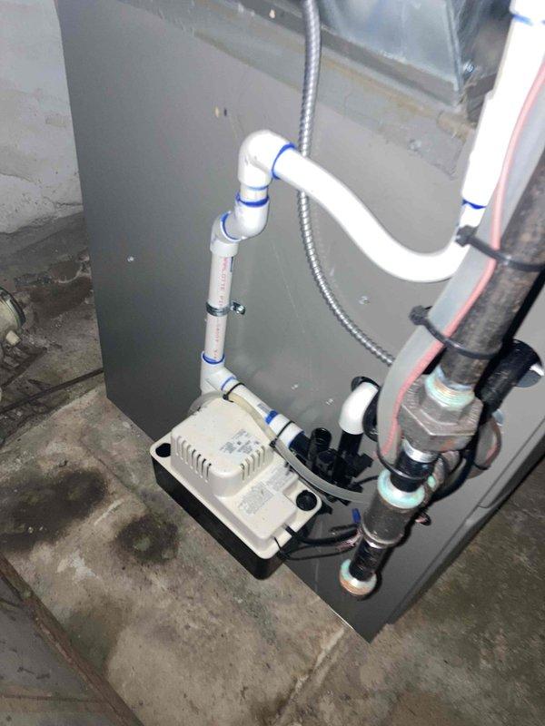 Completed annual AC maintenance and tune-up on residential air conditioning system. Performed comprehensive inspection of indoor air handler unit including blower wheel assembly, which showed clean condition with properly functioning squirrel cage fan and intact blades. Verified blower motor shaft, collar, and mounting components operating correctly with no signs of wear or misalignment. Inspected condensate drainage system including drain pan, condensate pump with visible intake ports, and associated PVC discharge piping with proper routing and elbow configurations. Confirmed electrical connections secure on condensate pump. Checked refrigerant lines with insulation properly secured. All system components found in good working order with no deficiencies noted. System operating within normal parameters.