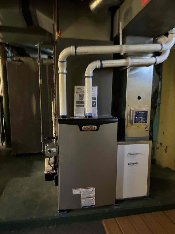 Completed full HVAC system installation in residential basement mechanical room. Installed new Lennox 90,000 BTU high-efficiency furnace with proper PVC intake and exhaust venting routed through 90-degree elbows. Installed 3-ton rear-discharge air conditioning system with appropriate refrigerant lines and electrical connections. Added humidifier to system for enhanced indoor air quality control. Reconnected all electrical circuits per code requirements and verified proper operation of all mechanical and electrical components. Mounted digital thermostat control on wall for system management. Installed GREE MATE cabinet unit as part of complete system integration. All venting, ductwork connections, and drainage lines properly secured and tested. System startup completed with full operational verification of heating, cooling, and humidification functions. All equipment operating within manufacturer specifications.
