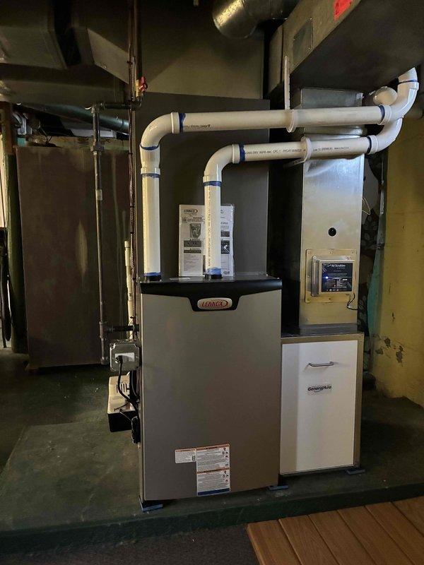 Completed full HVAC system installation in residential basement mechanical room. Installed new Lennox 90,000 BTU high-efficiency furnace with proper PVC intake and exhaust venting routed through 90-degree elbows. Installed 3-ton rear-discharge air conditioning system with appropriate refrigerant lines and electrical connections. Added humidifier to system for enhanced indoor air quality control. Reconnected all electrical circuits per code requirements and verified proper operation of all mechanical and electrical components. Mounted digital thermostat control on wall for system management. Installed GREE MATE cabinet unit as part of complete system integration. All venting, ductwork connections, and drainage lines properly secured and tested. System startup completed with full operational verification of heating, cooling, and humidification functions. All equipment operating within manufacturer specifications.