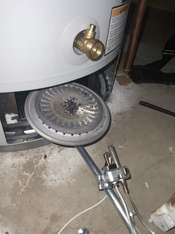 Performed water heater club membership maintenance inspection and service. Disassembled and cleaned burner assembly, removing accumulated debris and carbon deposits from burner surface. Inspected gas valve, thermocouple, and pilot assembly for proper operation. Verified all safety controls functioning correctly and reassembled unit to manufacturer specifications.