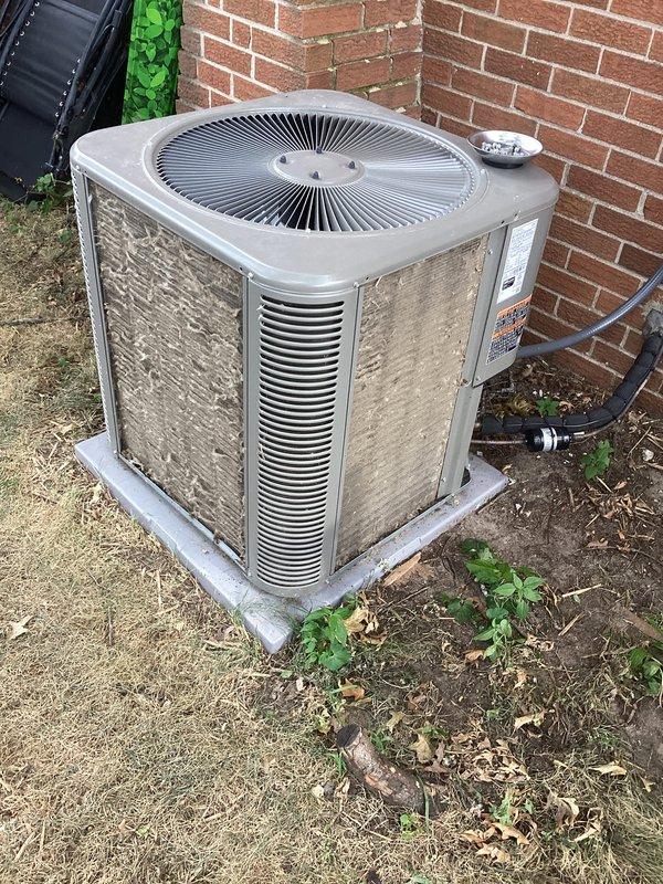 Responded to no-cooling call for outdoor AC condensing unit that would not turn on. Upon arrival, performed diagnostic testing of the electrical system using clamp meter, which revealed a current draw of 7.48 amps. Inspected outdoor unit positioned against building exterior, noting weathered cabinet condition with accumulated dirt and debris around base and on mesh panels. Evaluated electrical connections, capacitor, and associated wiring at disconnect box. Unit was successfully restored to operational status during maintenance agreement visit.