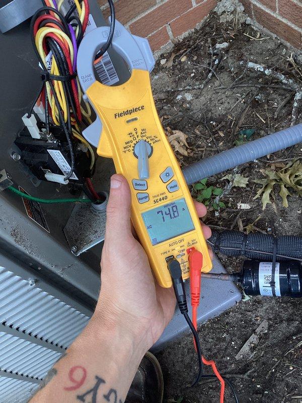 Responded to no-cooling call for outdoor AC condensing unit that would not turn on. Upon arrival, performed diagnostic testing of the electrical system using clamp meter, which revealed a current draw of 7.48 amps. Inspected outdoor unit positioned against building exterior, noting weathered cabinet condition with accumulated dirt and debris around base and on mesh panels. Evaluated electrical connections, capacitor, and associated wiring at disconnect box. Unit was successfully restored to operational status during maintenance agreement visit.
