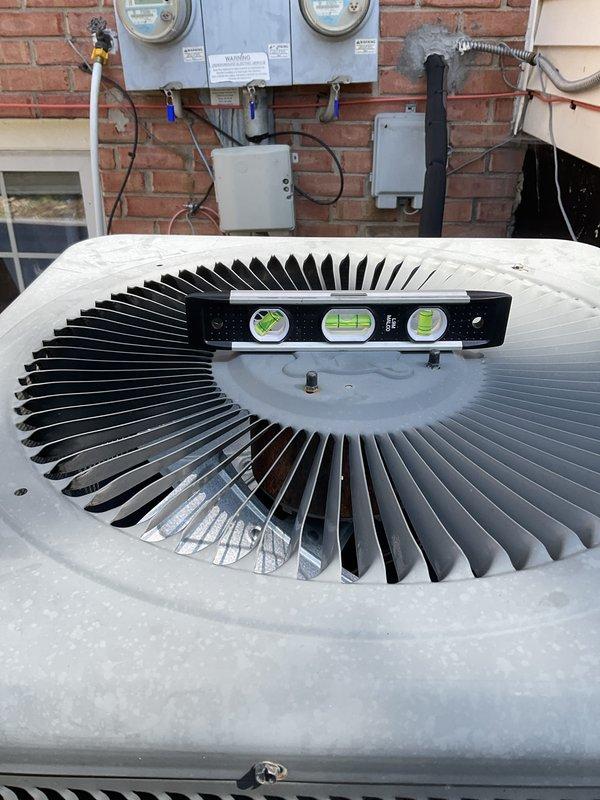Responded to service call for water pooling under 4-year-old AC condenser unit following heavy rain. Upon inspection, found condenser unit unlevel, causing improper drainage from the condensate system. Verified condenser coils were clean and system was maintaining proper cooling operation with no refrigerant issues. Leveled outdoor condenser unit using adjustable pad, ensuring proper pitch for water drainage away from unit. Confirmed unit stability and tested system operation. System now draining properly with no water accumulation at base.