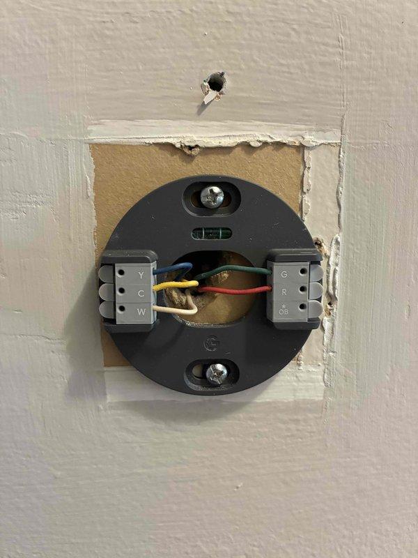 Conducted on-site evaluation for AC unit replacement. Assessed existing thermostat installation and wiring configuration, documenting current system setup including wire terminals and mounting condition. Evaluated smart thermostat currently in safety mode at 40°F with indoor temperature reading of 79°F, indicating potential system malfunction or improper operation requiring replacement estimate.