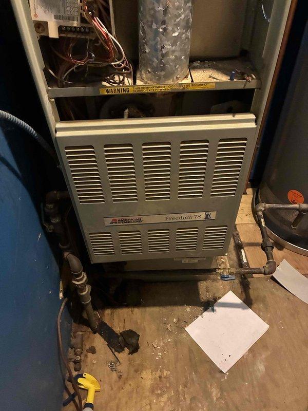 Completed comprehensive HVAC system evaluation for replacement estimate on existing American Standard Freedom 95 furnace installation. Documented current equipment condition including visible moisture accumulation on internal ductwork, assessed overall system configuration with copper refrigerant lines and electrical connections, and photographed installation setup to provide accurate replacement specifications for customer consideration.