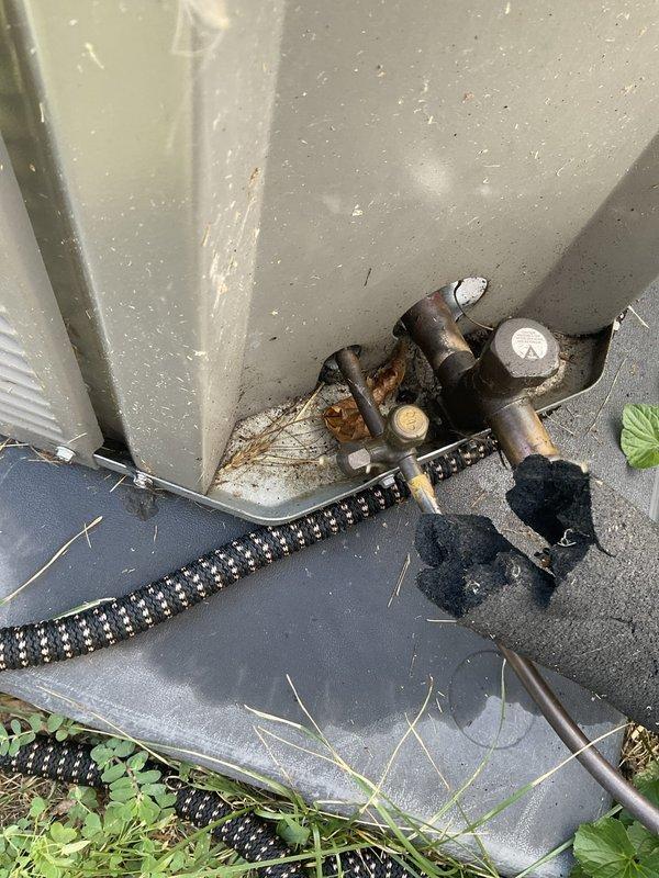 Responded to service call for AC unit leaking in basement. Upon inspection, discovered water damage and staining on ceiling near refrigerant lines and condensate drainage system. Identified improper condensate drain routing causing water accumulation. Cleared condensate line obstruction, verified proper drainage flow, and confirmed AC unit operation. Documented conditions with photos showing exterior condensate discharge point and interior water damage requiring monitoring.