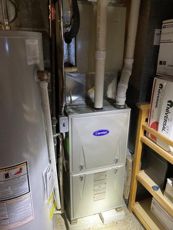 Provided replacement estimate for 20-year-old R22 residential HVAC system including outdoor condenser unit and Carrier gas furnace located in basement. Current system operational but at end of service life with obsolete refrigerant. Documented existing equipment configuration including refrigerant line routing, venting arrangement, and installation conditions for comprehensive replacement proposal.