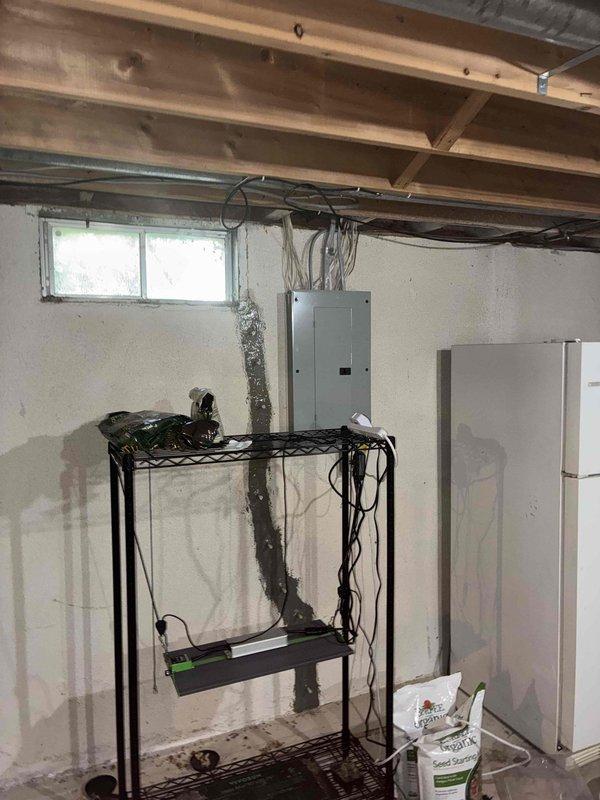 Conducted estimate for R22 refrigerant system with reported flat/no cooling condition. Inspected Nest thermostat installation and wiring configuration, documenting terminal connections including Y1, Y2, G, RC, W1/E, W2/AUX, and C terminals with multiple blue wires and red wire properly connected. Evaluated basement mechanical area with exposed HVAC ductwork and electrical infrastructure to assess system accessibility and replacement requirements for aging R22 equipment.