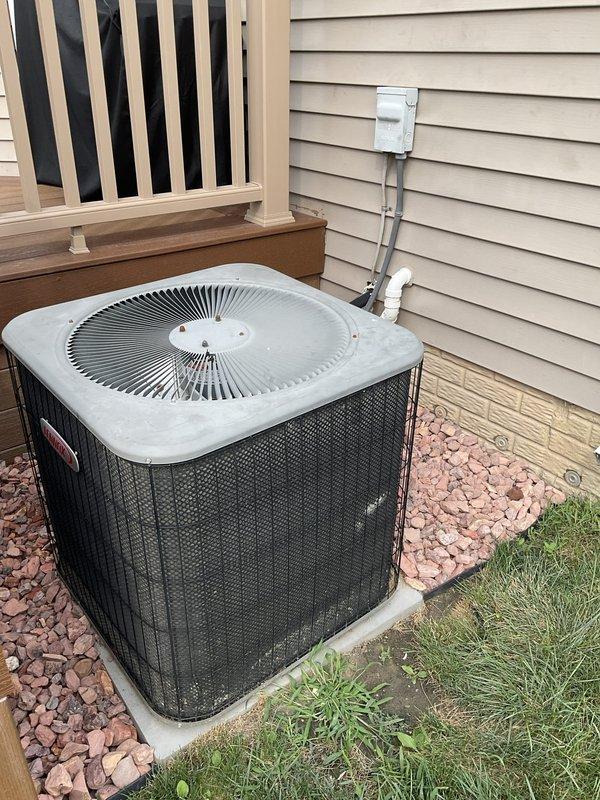 Conducted replacement estimate for residential Goodman condensing unit experiencing low refrigerant charge. System utilizes R22 refrigerant, which is being phased out and increasingly expensive to service. Evaluated existing outdoor condenser positioned on concrete pad adjacent to deck structure, documented current equipment condition and installation configuration. Discussed replacement options with decision maker present on-site, provided recommendations for upgrading to newer, more efficient system compatible with current refrigerant standards.