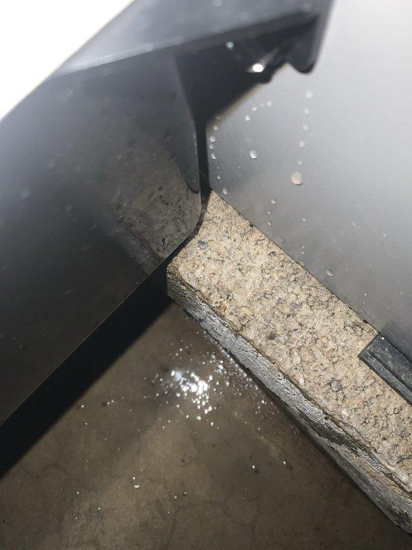 Responded to service call for humidifier leak on HVAC system less than 10 years old. Upon inspection, discovered active water leakage at humidifier assembly with visible moisture accumulation on surrounding ductwork, insulation materials, and base surfaces. Documented leak location and extent of water damage with photos showing condensation and water droplets at equipment junction points where metal ductwork meets insulation board and floor panel.