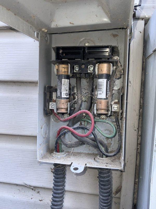 Responded to no cooling complaint on 10+ year old Goodman TCUD6941S3A unit. Upon inspection, found outdoor disconnect box with heavily corroded fuse holders, deteriorated wiring connections, and significant debris accumulation affecting electrical supply to condensing unit. Cleaned disconnect box, replaced corroded fuses, tightened all electrical connections, and verified proper voltage supply to equipment, restoring cooling operation to system.