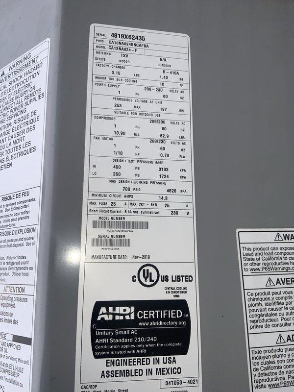 Responded to no cooling complaint on a seven-year-old residential air conditioning system. Upon arrival, verified system was running but delivering room temperature air throughout the home. Inspected outdoor condensing unit, a Goodman model CA13NA024ENGAF8A manufactured in November 2019. Checked electrical disconnect and confirmed power supply to unit. Documented equipment nameplate data including serial number 4819X62435 and electrical specifications showing 208-230 volts AC operation. System appeared to be operating mechanically but not producing cooling as expected, consistent with reported symptoms of failed cooling capacity despite unit running normally.