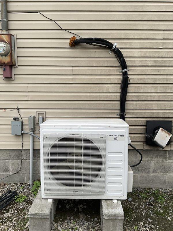 Conducted estimate for replacement of power surge-damaged mini split system serving garage area. Evaluated existing Thermocore outdoor condenser unit mounted on concrete pad with refrigerant lines running to interior wall-mounted air handler. Assessed electrical connections, refrigerant line routing, and mounting locations to provide replacement options for complete ductless mini split system.